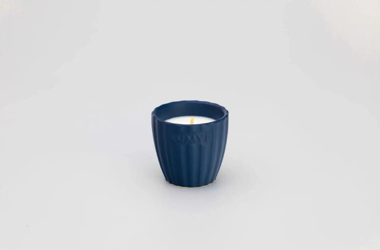 Granatowa świeca w ceramicznej osłonce.